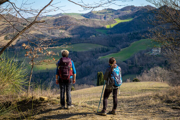 Two women with backpack  admiring the apennines. Modigliana, Forlì, Emilia Romagna, Italy, Europe.