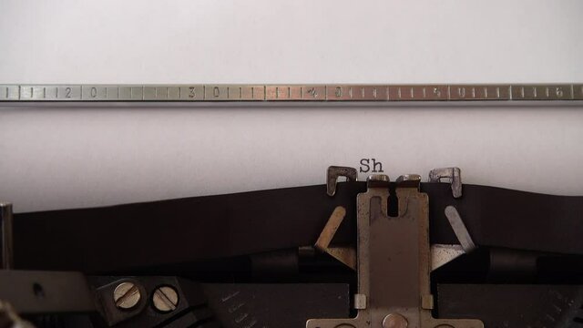 Typing phrase Sharia Low on retro typewriter. Close up.