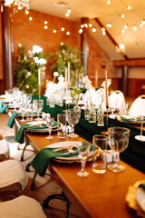 Beautiful decorated table for the event in the restaurant in emerald color. Wedding, birthday, party, event concept.