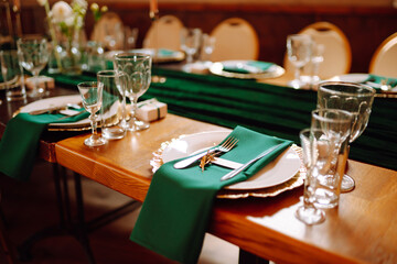 Beautiful decorated table for the event in the restaurant in emerald color. Wedding, birthday, party, event concept.