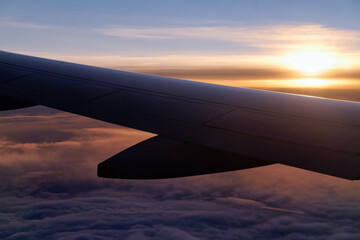 Fototapeta na wymiar Wing of plane in cloudy sky