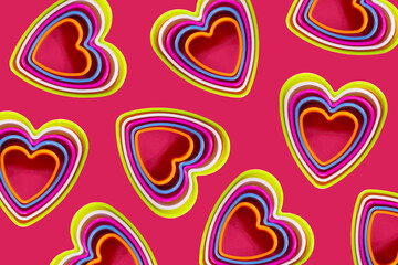 Fototapeta na wymiar Pattern of heart shaped cookie cutters on a pink background. Romantic valentine's day dinner.