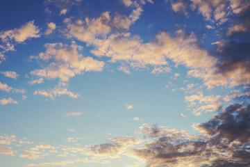 Blue sky, light and dark clouds at sunset. Cloudscape background or backdrop. Natural wallpaper. End of a sunny day