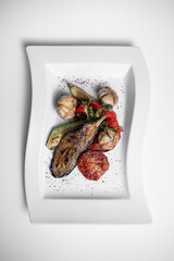 top view of grilled vegetables and champignon on white plate on white background