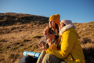 Fototapeta premium Two women on hiking trip eating cookies