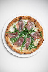 top view of tasty pizza with prosciutto, arugula and cheese on white background
