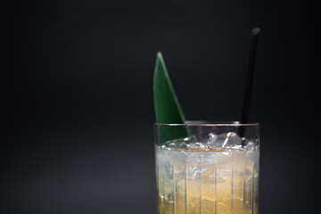 refreshing lemonade drink or cocktail with ice cube in glass on black background