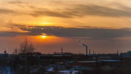 Fototapeta na wymiar Sunset over the industrial area of the city in winter