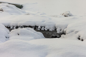 Icicles and frost on a snow-covered frozen river