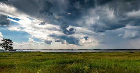 The sky with thunderclouds on the pond in summer