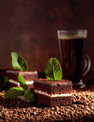 Chocolate cake on a table with coffee beans.