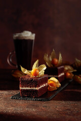 Chocolate cake with physalis on a brown background.