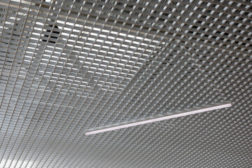 LED lighting lamp on the ceiling of an commercial building. Grid structure of suspended ceiling in...