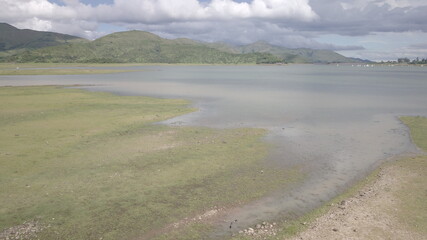 Lake between green mountains and cloudy sky (D-Log profile)