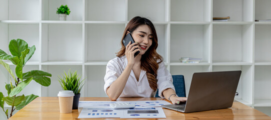 Businesswoman talking on the phone with her business partner, she sits in a private room, in a room...