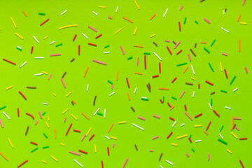 trendy pattern of colorful sprinkles for background of design banner, poster, flyer, card, postcard, cover, brochure over green