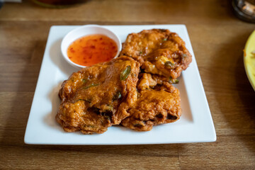 Thai Fish cakes with sweet chili sauce on a white plate
