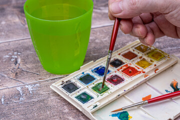 Selective focus.of an artists  set of half pan watercolor paints in a plastic folding box with...