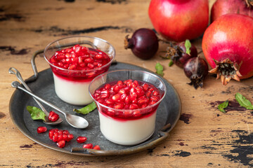 Fresh plain yogurt with pomegranate seeds in a glass jars for breakfast
