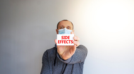 Side effects symbol. White card, words Side effects. A young man in a grey wear and medical mask....