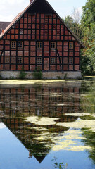 old buildings by the pond are reflected in the water