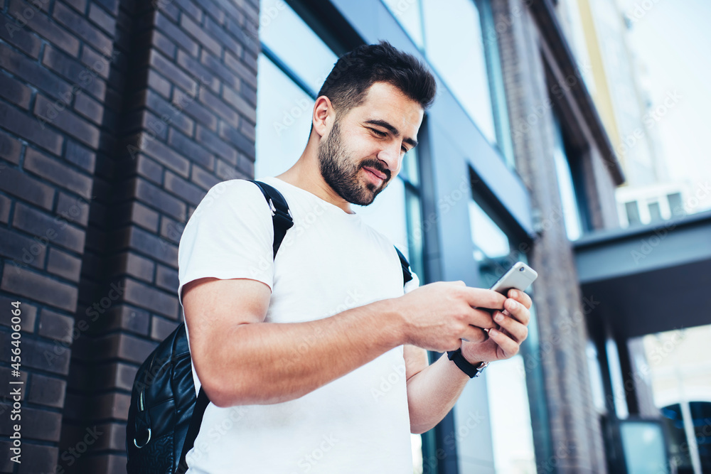 Poster young male travel blogger browsing website on cellphone device using 4g wireless for checking gps on