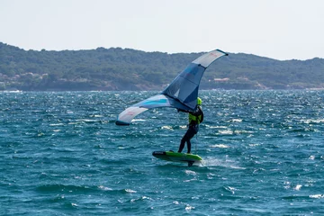 Foto op Aluminium Hyeres, Almanarre beach, France, July 10, 2021. Extreem water sport - wing foil, kite surfing, wind surfindg, windy day on Almanarre beach near Toulon, South of France © barmalini