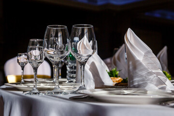 beautiful table setting. glasses, plates on round table in sunlight