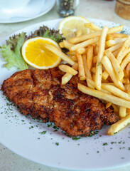 Wiener Schnitzel served with french fried potato and fresh salad