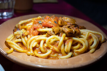 Italian vegetarian dish macaroni with golden chanterelles mushrooms and tomatoes