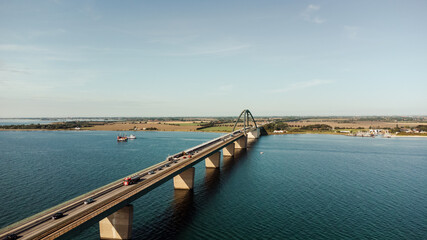 Fototapeta na wymiar Luftaufnahme einer großen Brücke mit Verkehr über einer Meerenge mit blauem Wasser und vielen Schiffen