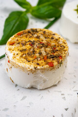 Cheese collection, variety of fresh white soft goat French cheeses with aromatic herbs, berries and green pesto
