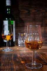 Glasses of strong scotch single malt whisky served on dark wooden table in old pub