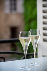 Romantic party with two glasses of white cold champagne and view on old street in French village