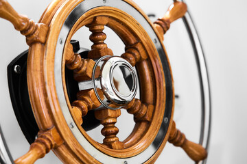Close up of steering wheel made of wood on a boat.