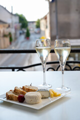 Romantic party with two glasses of white cold champagne and view on old street in French village