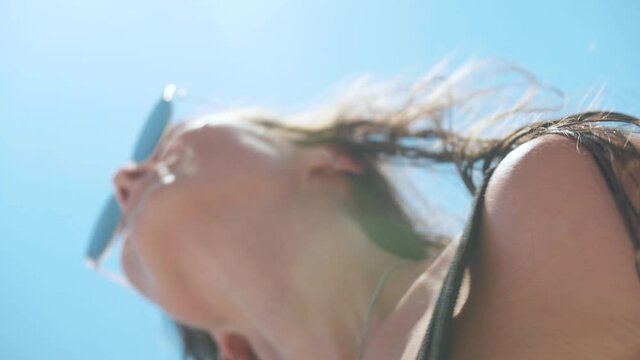 woman in a swimsuit sunglasses dances the sea, the sun