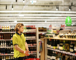 man choosing a wine, champagne at supermarket	