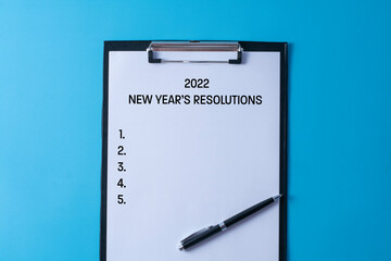 2022 new year's resolutions written in a paper on clipboard - business concept.