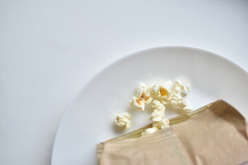A bag of popcorn open on a plate in the kitchen