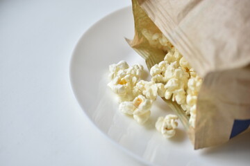 A bag of popcorn open on a plate in the kitchen