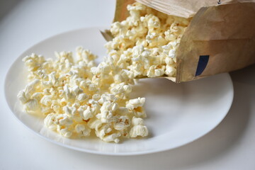 A bag of popcorn open on a plate in the kitchen