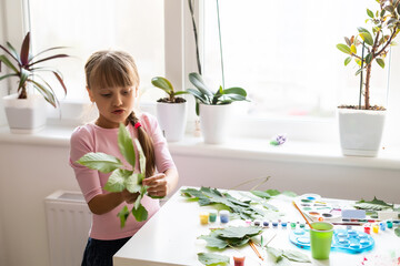 schoolgirl paint the leaves at home