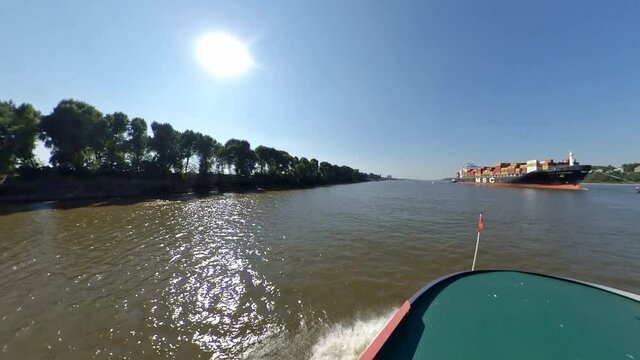 Hafenf&auml;hre auf der Elbe in Hamburg mit Containerschiff vom Wasser aus