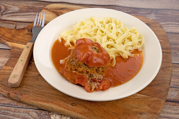 tomate farcie et tagliatelles dans une assiette