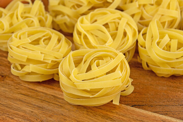 pâtes tagliatelles crues sur une planche à découper
