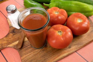 jus de tomate frais dans un verre et légumes frais