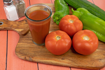 jus de tomate frais dans un verre et légumes frais