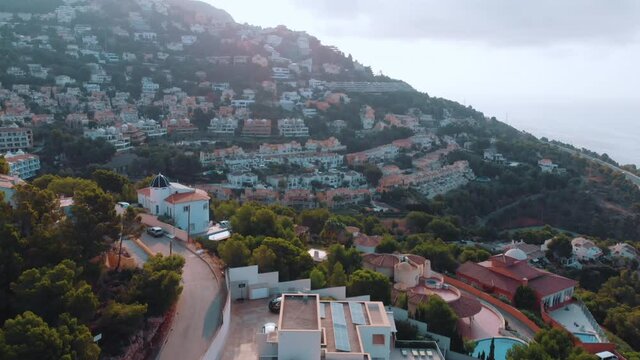 Altea Hills, a tourist spot in Benidorm, Spain. Beautiful holiday villas and hills can be seen. Scenic mountains against a cloudy sky in the background. Slow-motion high-quality daytime footage.