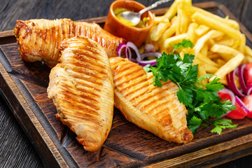chicken breasts with french fries and salad